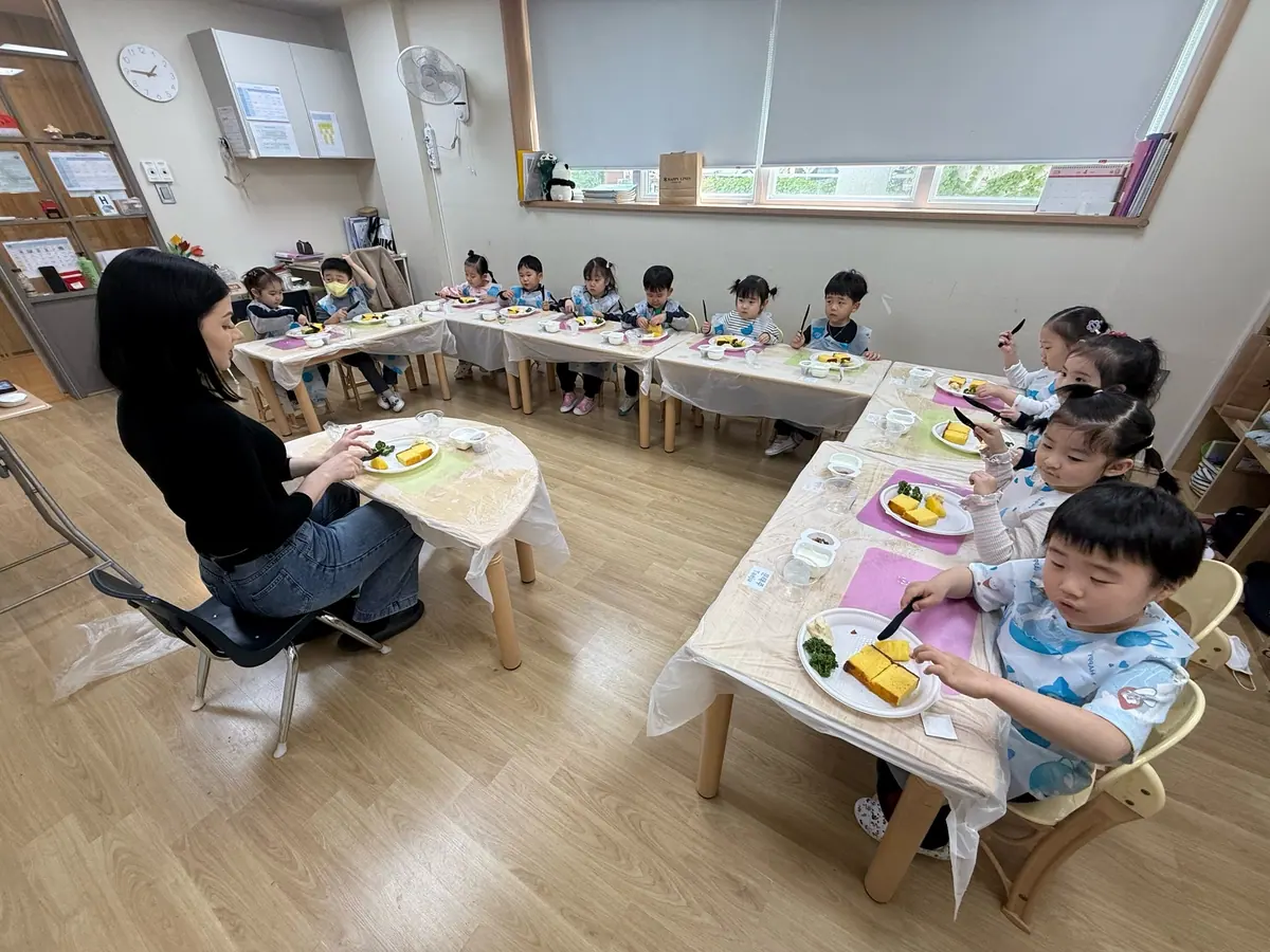 함께 배우는 식사 예절: 선생님과 나란히 앉아 식사 예절을 익힙니다.